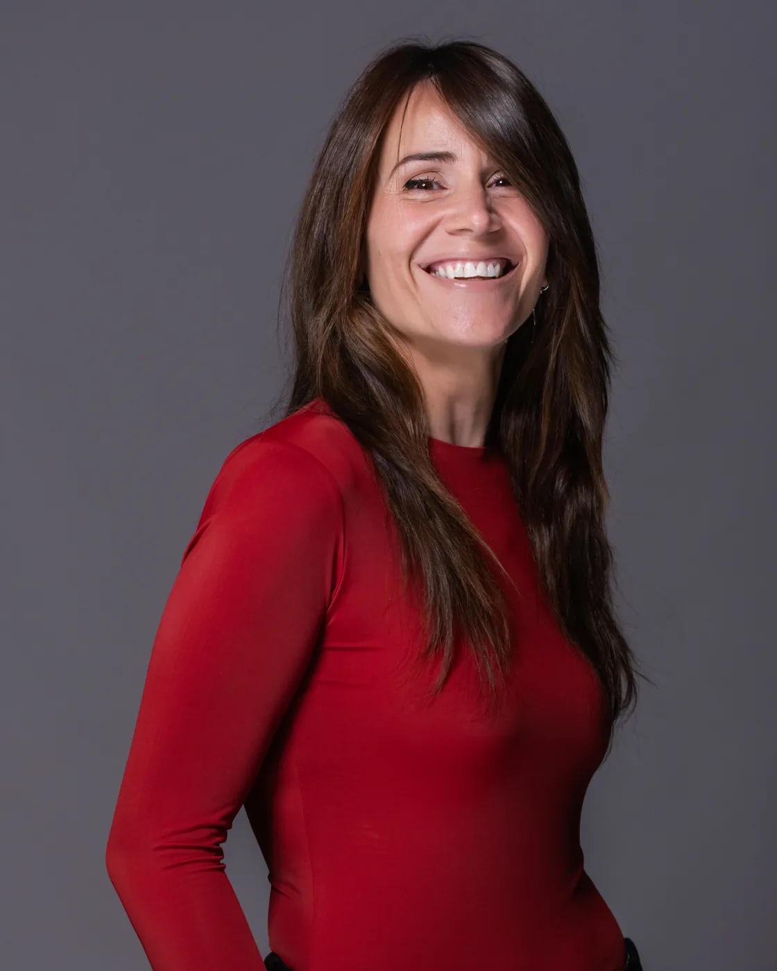 Miriam Martín sonriendo en retrato de estudio con jersey rojo